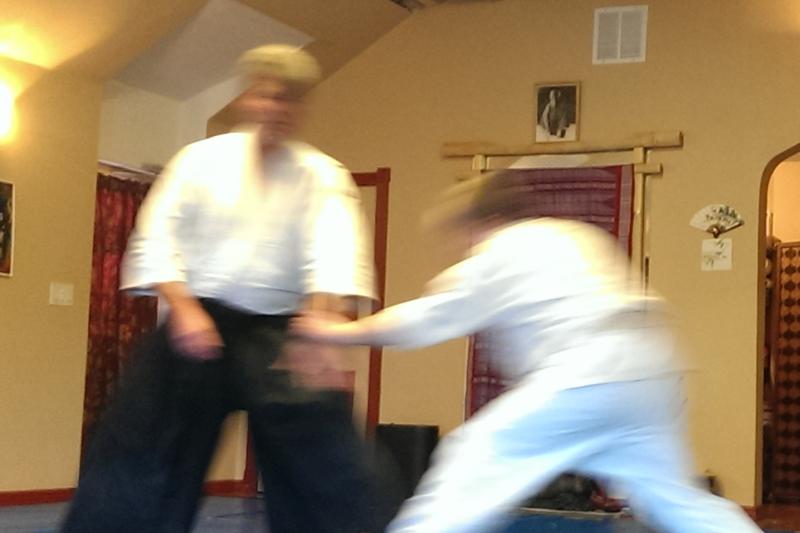 Two people blurred due to motion. The person on the right is reaching for the wrist of the person on the left.